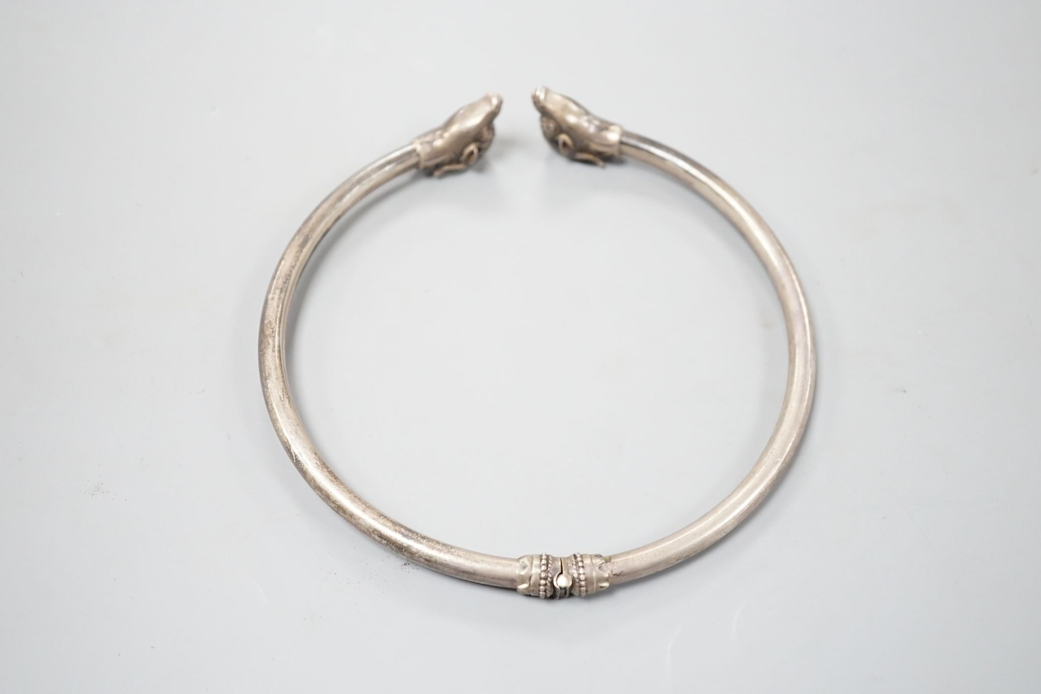 A modern 925 torque necklace, with ram's head terminals, overall diameter 14.2cm, 83 grams.